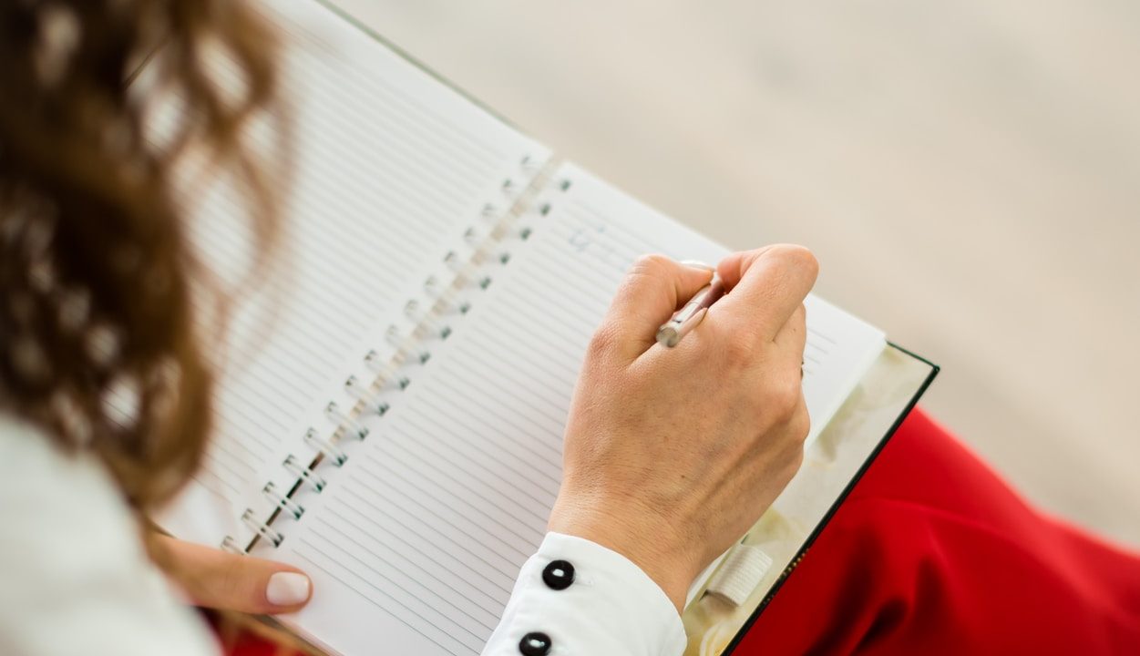 woman in red blazer holding white paper